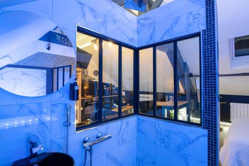 a bathroom with a large window in a room at L'Intemporel Éclipse Suite Spa Privatif in Champagne-sur-Oise