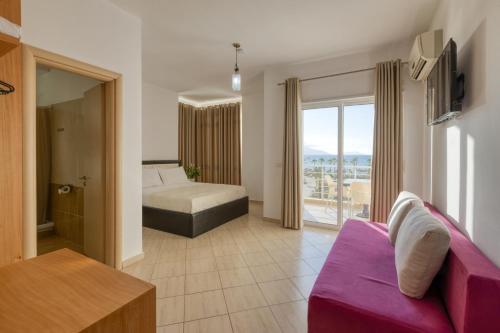a living room with a purple couch and a bed at Hotel Bella Vista in Orikum