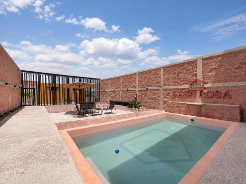 a swimming pool in front of a brick building at Casa Rosa in Aguascalientes
