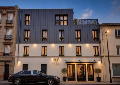 a black car parked in front of a building at La Maison Solférino in Boulogne-Billancourt