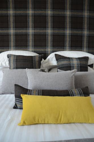 a group of pillows on a bed with a yellow pillow at Edinburgh37 in Edinburgh