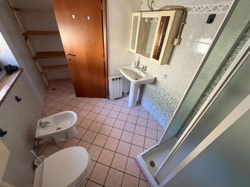 a bathroom with a toilet and a sink at Maison Jaune 26 in Aosta