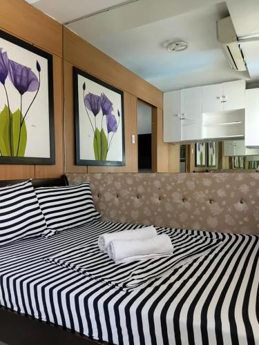 two beds in a room with purple flowers on the wall at Shell Residences MOA Elegant Place in Manila