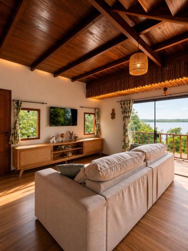 a living room with a large couch and a large window at Vila da Mata in Alter do Chao