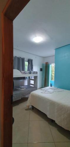 a bedroom with a bed and a shelf with shoes on it at Hospedaria Mandassaia in Lençóis