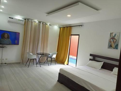 a bedroom with a bed and a table and chairs at CarteSurTable - Votre havre de paix aux portes de la ville - Villa haut standing in Yamoussoukro