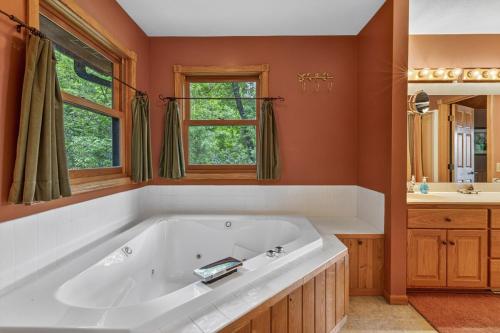 a large white tub in a bathroom with orange walls at Next Chapter Family Retreat in Pequot Lakes