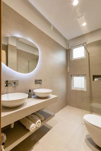 a bathroom with two sinks and a mirror at Hotel Bella Vista in Orikum