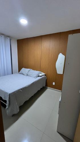 a bedroom with a bed and a wooden wall at Apartamento completo, moderno e bem localizado in Parnamirim