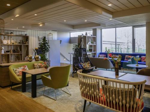 a lobby with tables and chairs in a store at Novotel Paris Créteil Le Lac in Créteil