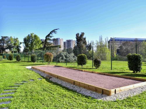 a park with a large sandbox in the grass at Novotel Paris Créteil Le Lac in Créteil