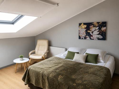 a bedroom with a large bed and a chair at KURESSAARE TALLINN STREET APARTMENTs in Kuressaare