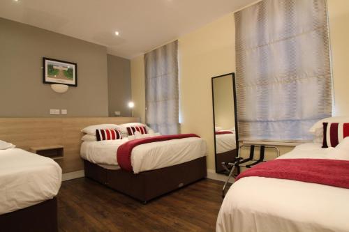 Habitación de hotel con 2 camas y espejo en Townlets Townhouse en Belfast