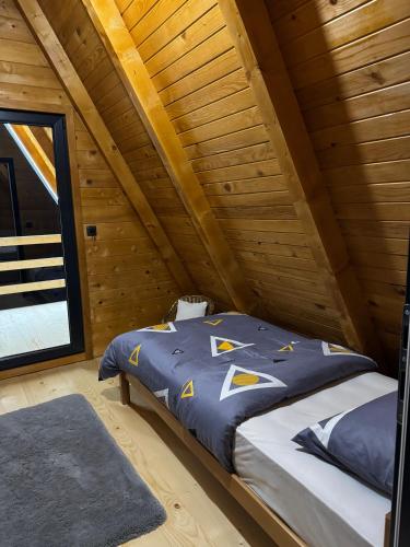 a bed in a room with a wooden ceiling at Vila Kalkan in Šipovo