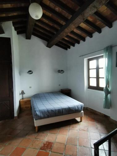 a bedroom with a bed in a room with a window at Maison de village, Verdon in Trigance