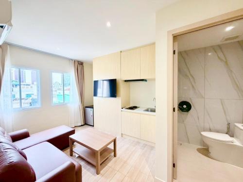 a living room with a couch and a kitchen at Le Hong Hotel Pratunam in Bangkok