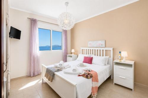 a bedroom with a white bed and a large window at Villa Situla in Barbati