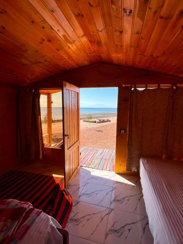 a room with a door open to the beach at Marhaba Camp in Nuweiba