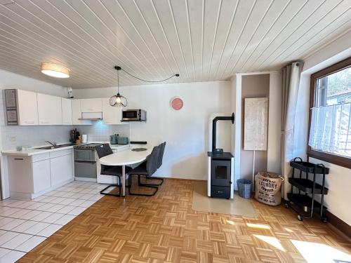 a kitchen with a table and a stove in a room at Ferienwohnung mit Terrasse - Hunde willkommen in Falkenstein
