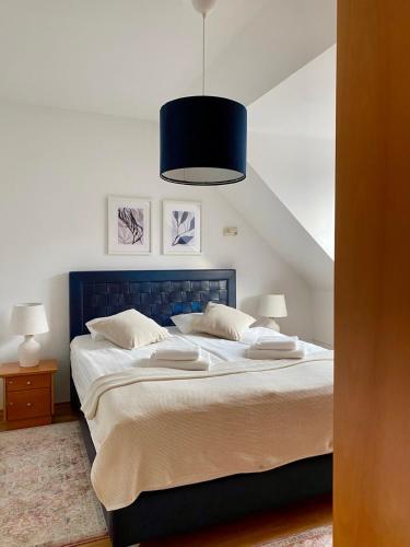 a bedroom with a large bed with a blue headboard at Lake Veronika in Bled