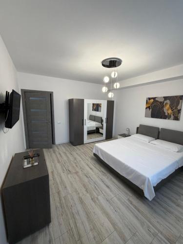 a bedroom with a large bed and a television at AKT Residence in Agigea