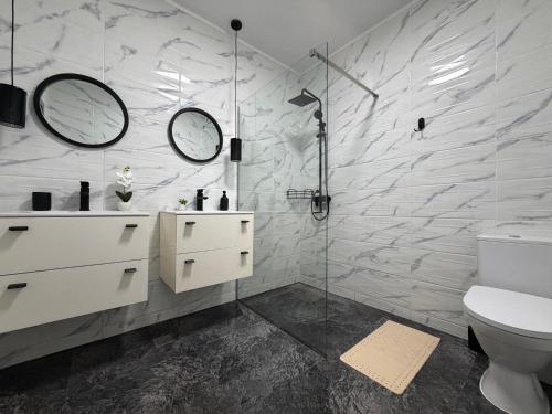 a bathroom with a toilet and a sink and mirror at AKT Residence in Agigea