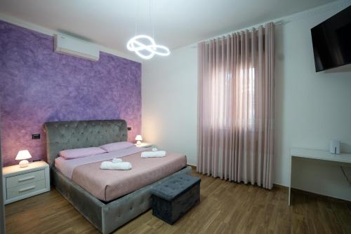 a bedroom with a bed and a purple wall at Casa Lady in Pontremoli