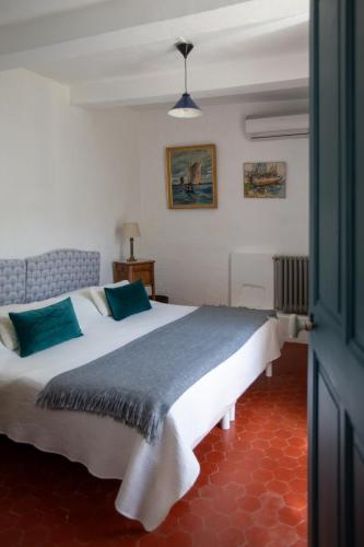a bedroom with a large white bed with blue pillows at Le Grand Gîte in Vaison-la-Romaine