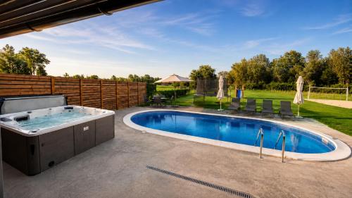 a swimming pool with a hot tub in a yard at Oaza Gradiška in Bosanska Gradiška