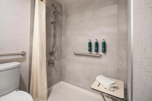 a bathroom with a shower with a toilet and a sink at DoubleTree by Hilton Fort Lee/George Washington Bridge in Fort Lee