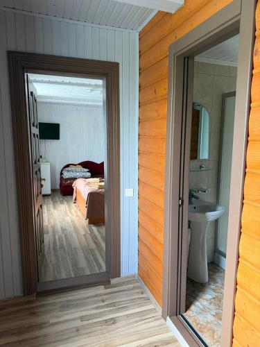 a bedroom with a bed and a door leading to a bathroom at Podolyanka in Slavske