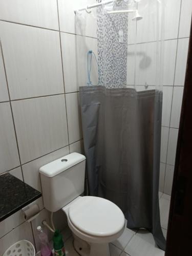 a bathroom with a toilet and a shower at Jacumã Beach House in Conde
