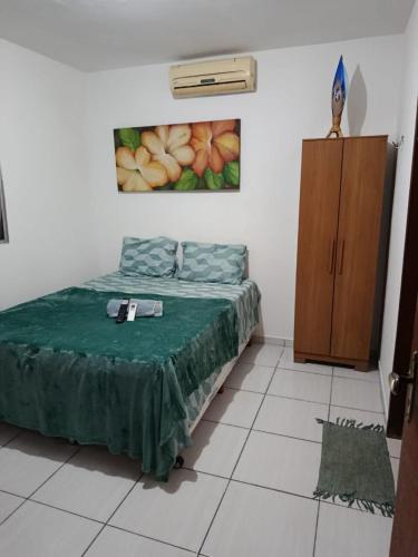 a bedroom with a bed and a cabinet in it at Jacumã Beach House in Conde
