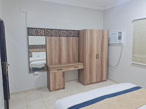 a room with a bed and a wooden cabinet at شقق مفروشة مكين 1 in Medina