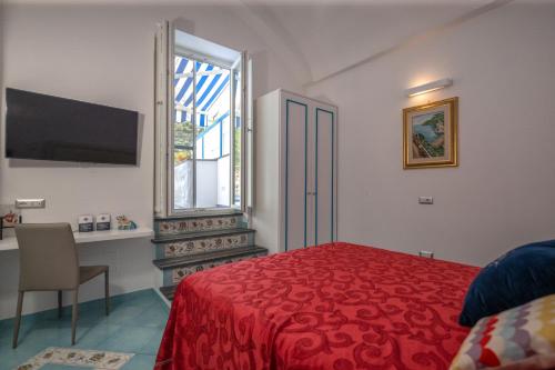 a bedroom with a red bed and a window at Grecale - stunning sea-view apartment with patio, up to 5 guests in Maiori