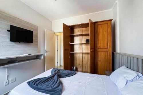 a bedroom with a bed with a tv on the wall at Vossa Bossa Olimpia in Olímpia