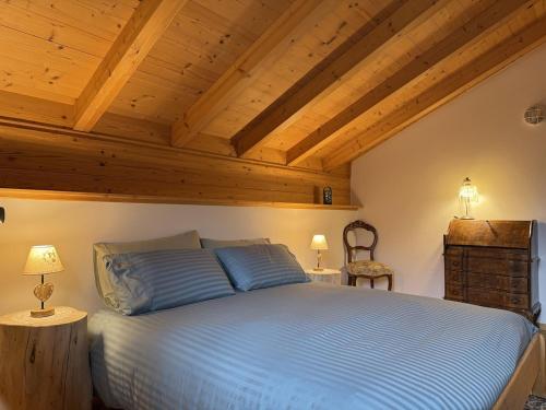 a bedroom with a large bed with wooden ceilings at Villetta Ximenes in Panchià
