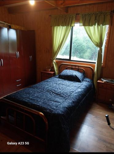 a bedroom with a bed and a window at Casa Halcon de Lagunitas in Puerto Montt