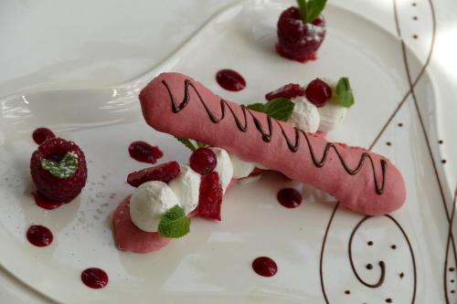 a dessert on a plate with strawberries and whipped cream at Logis Hotels Le Champalud Restaurant La Citadelle in Champtoceaux