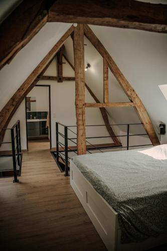 a bedroom with a bed in a room with wooden beams at Le loft de Marthe in Bonnières