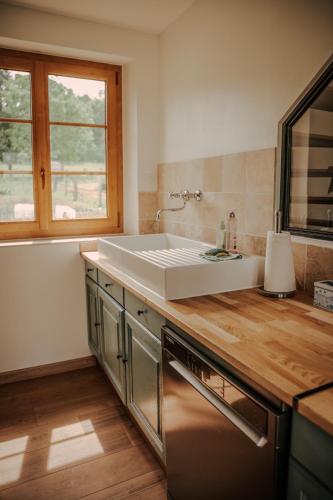 a kitchen with a white sink and a window at Le loft de Marthe in Bonnières