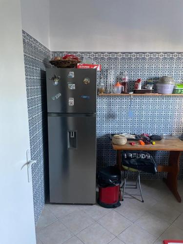 a refrigerator in a kitchen next to a table at SecretVilla in Ghār al Milḩ