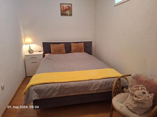 a bedroom with a bed with a yellow blanket at Stan na dan Grahovo in Bosansko Grahovo