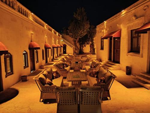 a row of tables and chairs in a courtyard at night at Aslan Guest House in Urfa