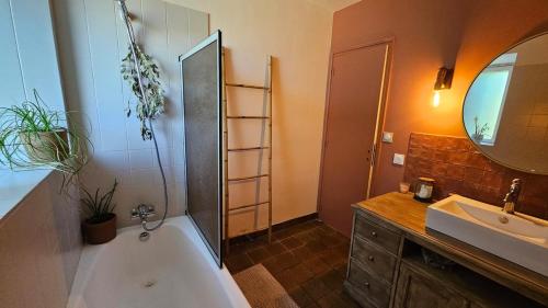 a bathroom with a tub and a sink and a mirror at Ker Bellevue, chambre Dinan in Lanvallay