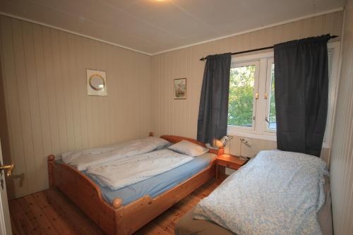 a bedroom with two twin beds and a window at Smia in Søgne