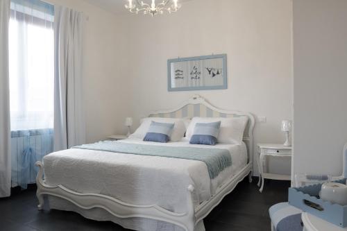 a white bedroom with a white bed and a chandelier at Annarè in Focene