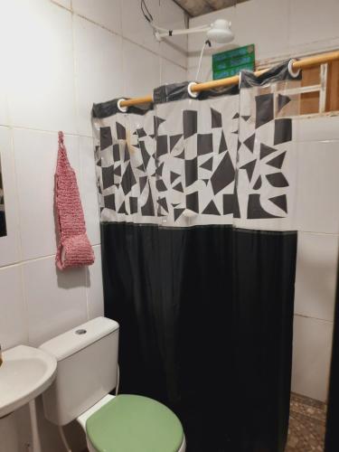 a bathroom with a green toilet and a shower curtain at Casa da Pri em São Jorge in Sao Jorge