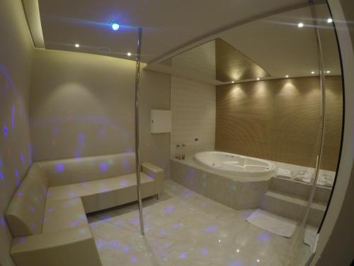 a bathroom with a shower and a tub and a sink at Motel Tenda in Maringá