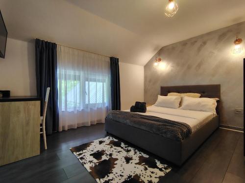 a bedroom with a large bed and a window at Vibe House Madisson in Braşov
